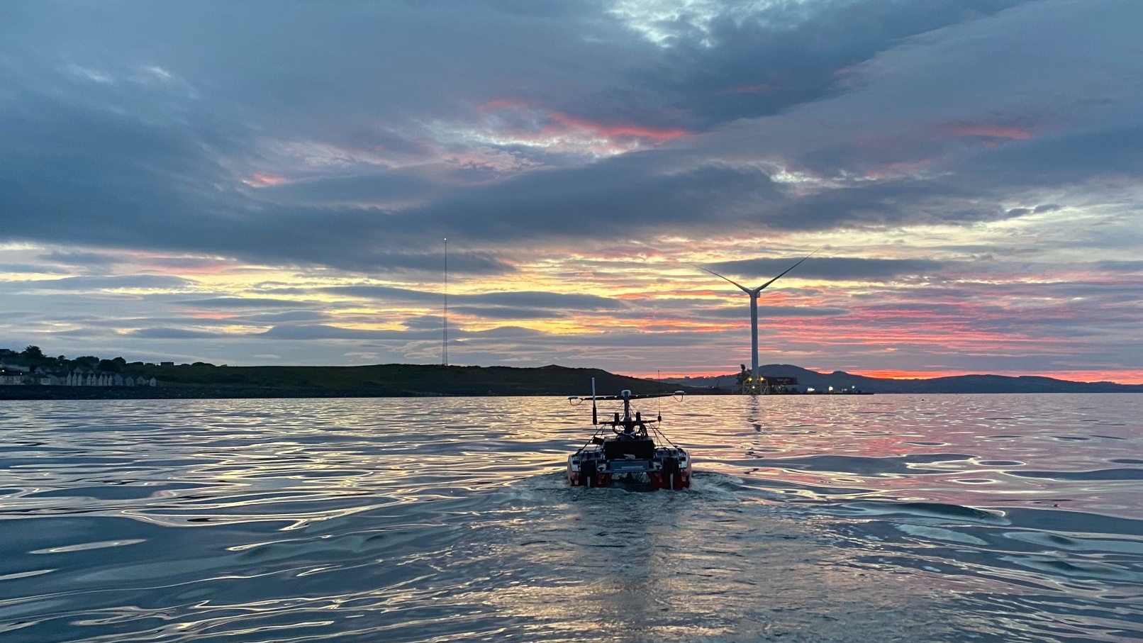 Unmanned surface vessel driving into sunset